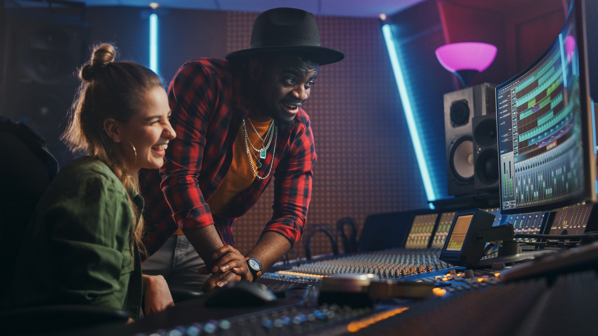 Stylish Producer and Audio Engineer Working together in Music Recording Studio on New Album, Talk, Use Control Desk Equalizer, Mixing Board and Software to Create Hit Song. Artist and Musician Collab